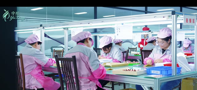 Team members working at a makeup brush assembly station