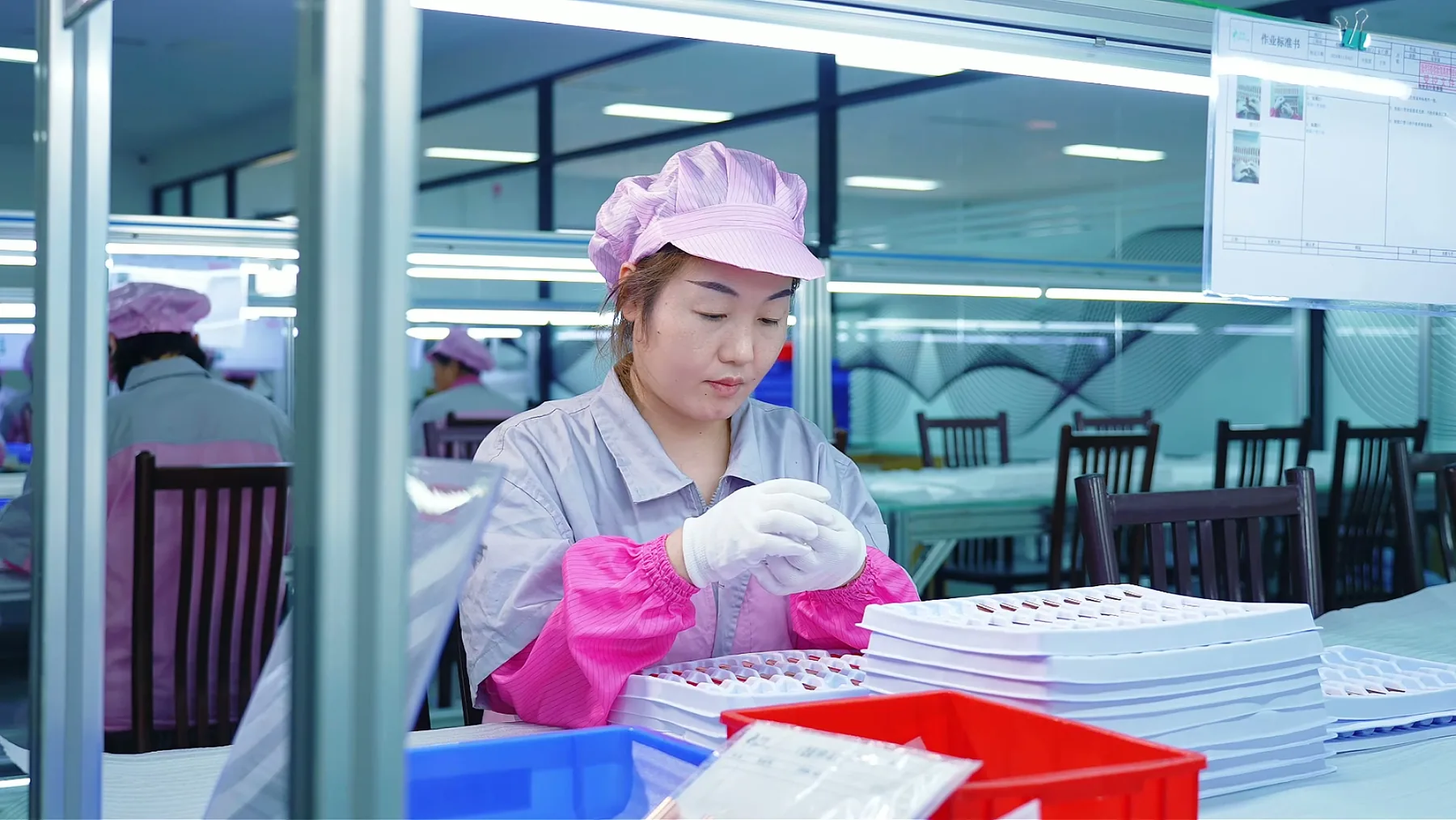 Operator performing detailed hand assembly of cosmetic brush parts