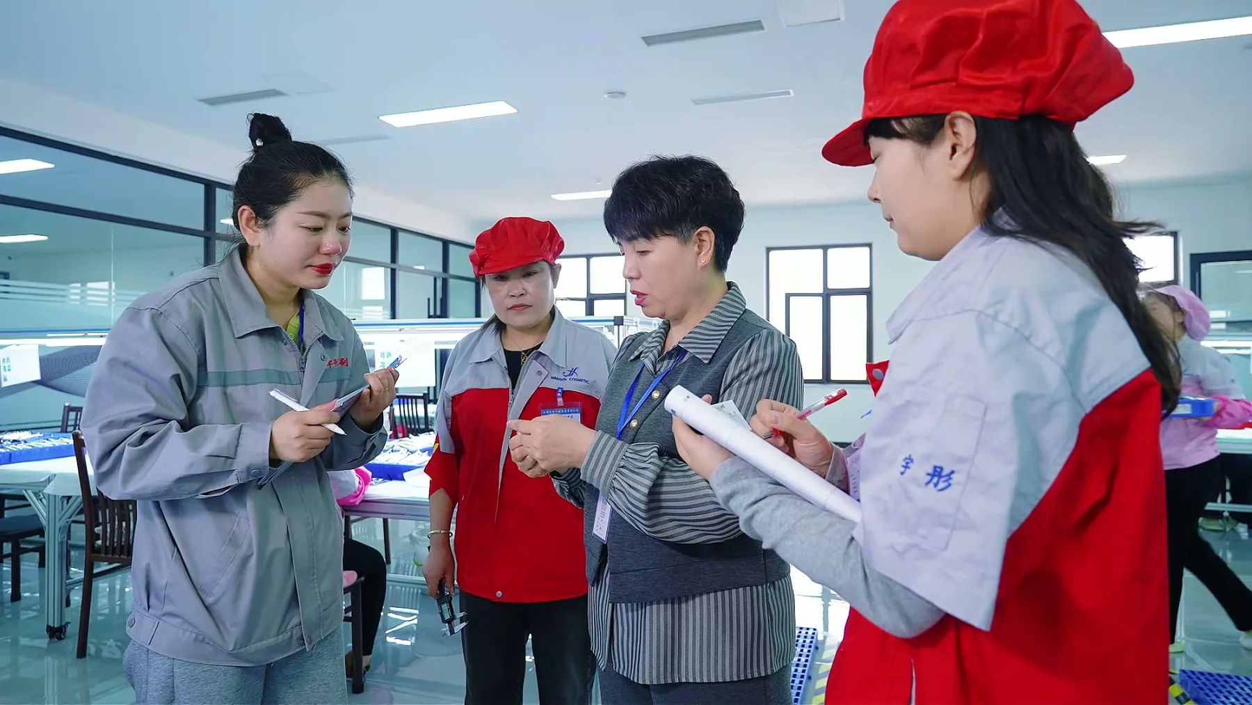 Production team reviewing cosmetic brush quality details on the workshop floor